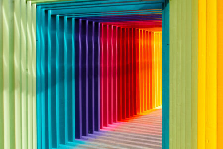 Bunte Lichtinstallation mit farbigen Streben in einem Raum.